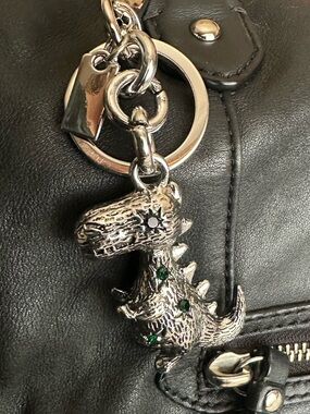 Silver dinosaur bag charm with green rhinestones. Heavy duty, great quality.